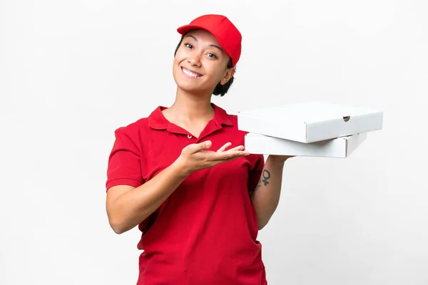 pizza delivery woman with work uniform picking up pizza boxes over isolated white background extending hands to the side for inviting to come