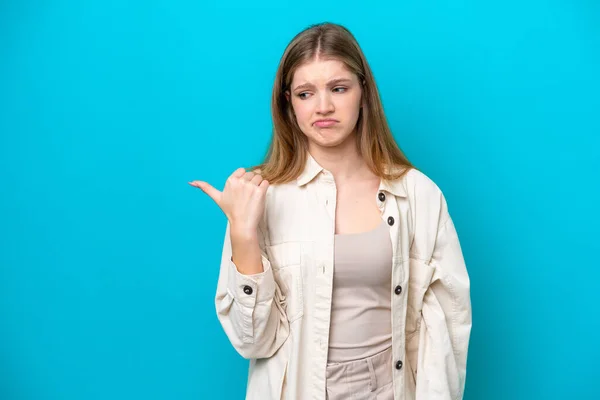 Teenager Russian Girl Isolated Blue Background Unhappy Pointing Side — Stok fotoğraf