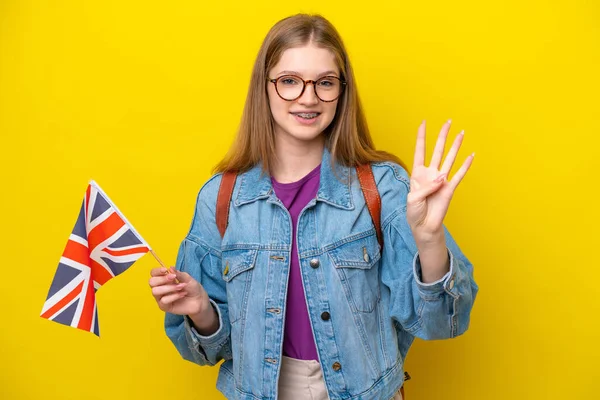 Teenager Russian girl holding an United Kingdom flag isolated on yellow background happy and counting four with fingers