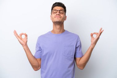 Beyaz arka planda Zen pozisyonunda beyaz tenli genç bir adam