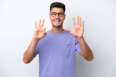 Beyaz arka planda izole genç beyaz adam parmakları ile sekiz sayın