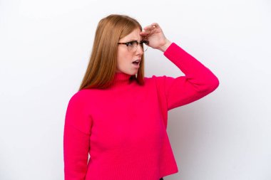 Genç kızıl saçlı kadın beyaz arka planda izole edilmiş. Sürpriz bir ifadeyle yan tarafa bakıyor.