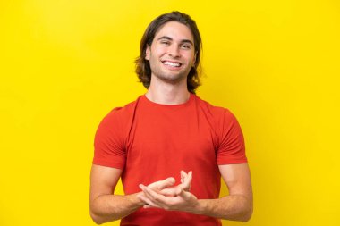 Caucasian handsome man isolated on yellow background laughing
