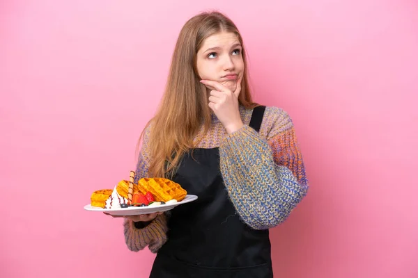 Teenager Russian Girl Holding Waffles Isolated Pink Background Having Doubts — Stock Photo, Image