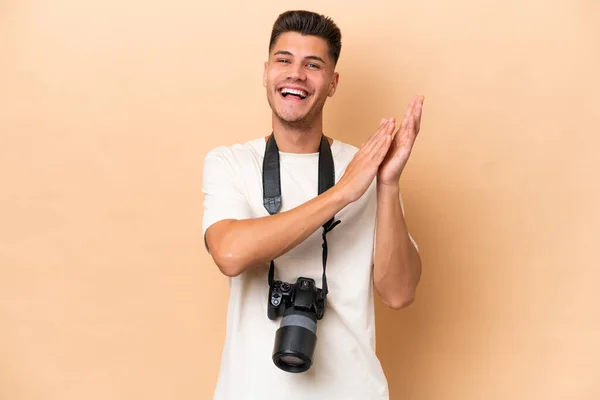 Young Photographer Caucasian Man Isolated Beige Background Applauding Presentation Conference — Stock Photo, Image