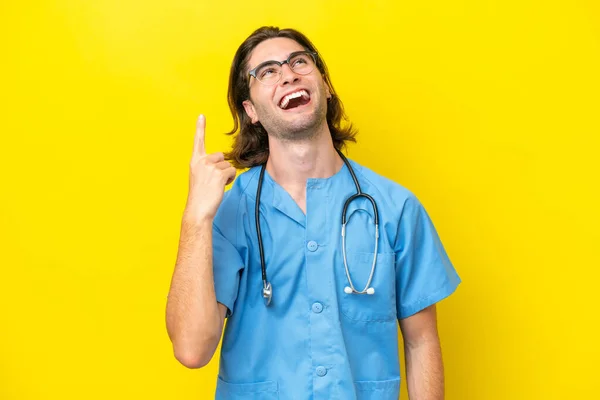 Mladý Chirurg Běloch Izolovaný Žlutém Pozadí Ukazuje Nahoru Překvapen — Stock fotografie