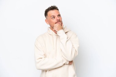 Beyaz arka planda izole edilmiş beyaz tenli yakışıklı bir adam yukarı bakarken bir fikir düşünüyor.