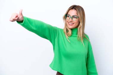 Genç Uruguaylı kadın beyaz arka planda izole edilmiş bir şekilde baş parmak işareti yapıyor.