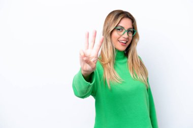 Genç Uruguaylı kadın beyaz arka planda izole edilmiş mutlu ve parmaklarıyla üçe kadar sayıyor.