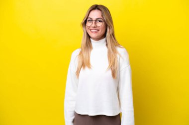 Young Uruguayan woman isolated on yellow background laughing