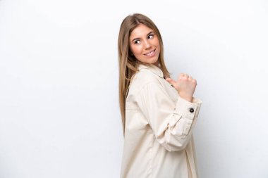 Young caucasian woman isolated on white bakcground pointing to the side to present a product
