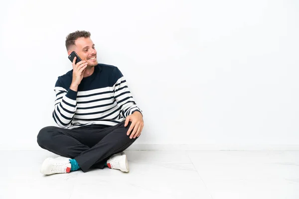 Young Man Sitting Floor Isolated White Background Keeping Conversation Mobile — стоковое фото