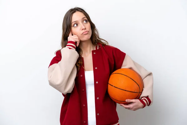 白人の背景に孤立したバスケットボールをしている若い白人女性がアイデアを考え — ストック写真