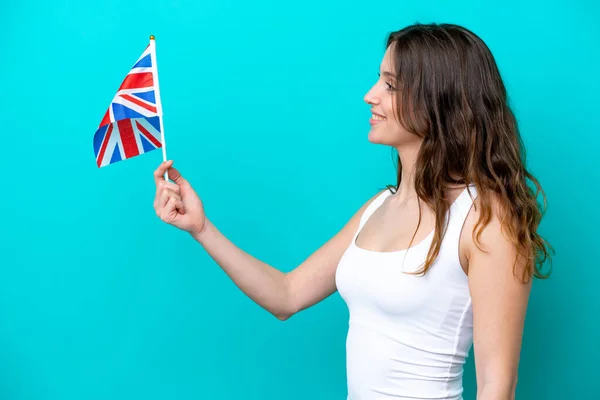 幸せな表情で青の背景に隔離された英語の旗を持つ若い白人女性 — ストック写真