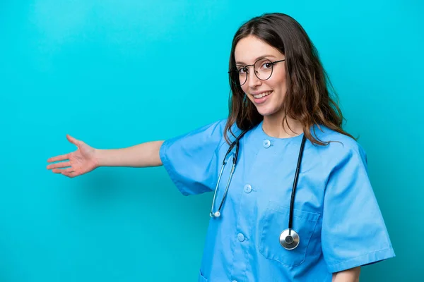 Młoda Chirurg Lekarz Kobieta Odizolowany Niebieskim Tle Wyciągając Ręce Boku — Zdjęcie stockowe