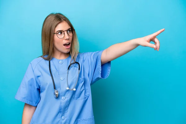 Young Surgeon Doctor Woman Isolated Blue Background Pointing Away — Stok fotoğraf