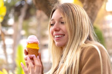 Açık havada kornet dondurmalı güzel sarışın kadın.