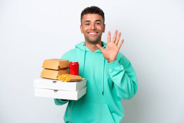 Fast food tutan genç Brezilyalı beyaz arka planda izole edilmiş, parmakları olan beş kişi saydım.