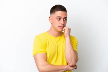 Genç Brezilyalı adam beyaz arka planda izole edilmiş, yorgun ve sıkılmış bir ifadeyle.