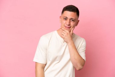 Pembe arka planda izole edilmiş genç Brezilyalı adamın şüpheleri var.