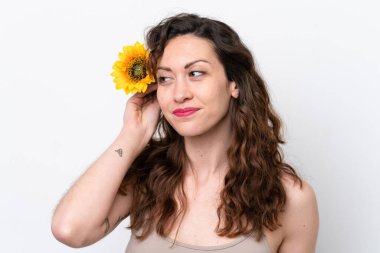 Beyaz arka planda izole edilmiş beyaz bir kadın elinde bir ayçiçeği tutuyor. Portreyi kapat
