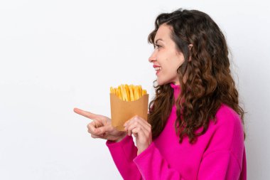 Beyaz arka planda izole edilmiş patates kızartması yakalayan beyaz bir kadın bir ürünü sunmak için kenarı işaret ediyor.