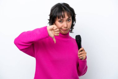 Young Argentinian singer woman isolated on white background showing thumb down with negative expression