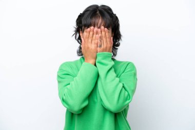 Arjantinli genç bir kadın beyaz arka planda izole edilmiş, gözleri elle kapatılmış.