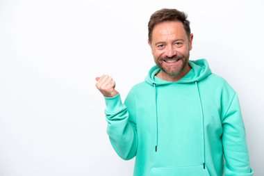 Beyaz arka planda izole edilmiş orta yaşlı beyaz bir adam bir ürün sunmak için kenarı işaret ediyor.