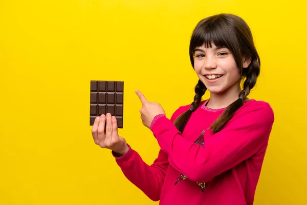 Malá Kavkazská Dívka Čokoládou Izolované Žlutém Pozadí Ukazuje Zpět — Stock fotografie