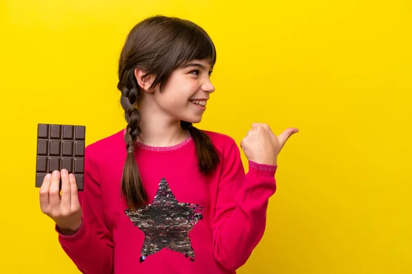 Little Caucasian Girl Chocolat Isolated Yellow Background Pointing Side Present — Stock fotografie
