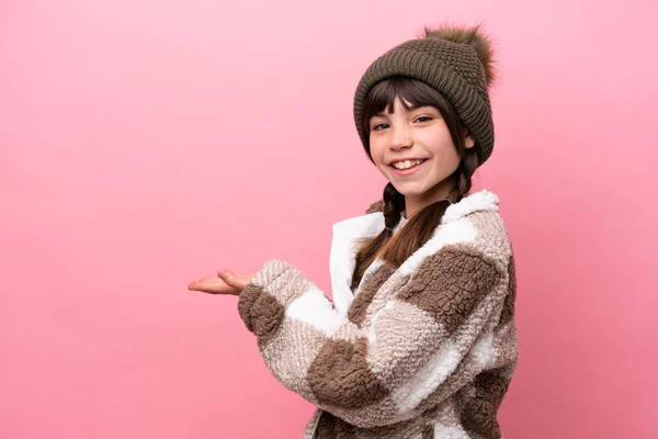 一个穿着冬季夹克的高加索小女孩 背景是粉色的 面带微笑地看着她 提出了一个想法 — 图库照片