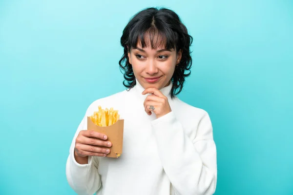 Young Argentinian Woman Holding Fried Chips Isolated Blue Background Looking — Stockfoto