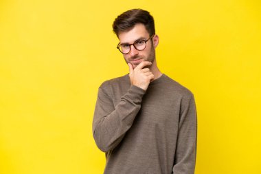 Sarı arka planda izole edilmiş genç beyaz adam mutlu ve gülümsüyor.