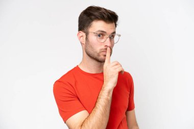 Young caucasian man isolated on white background With glasses and doing silence gesture