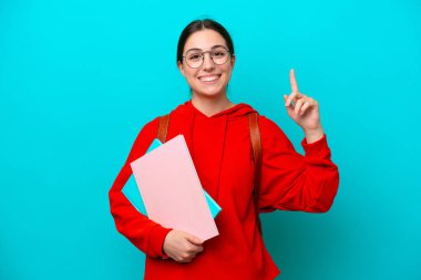 Young student caucasian woman isolated on blue background pointing up a great idea