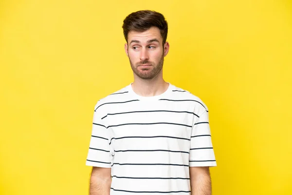 Young Caucasian Man Isolated Yellow Background Making Doubts Gesture Looking — Photo