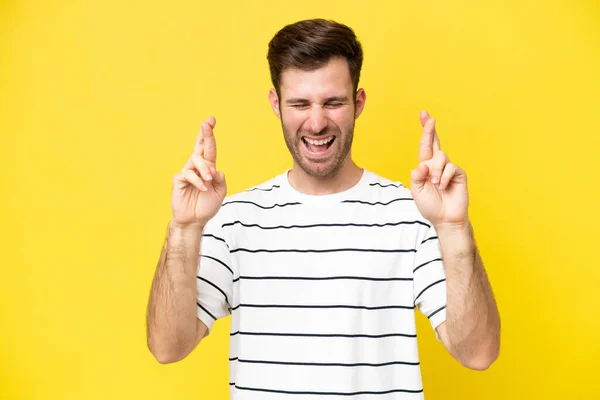 Young Caucasian Man Isolated Yellow Background Fingers Crossing — Stock Photo, Image