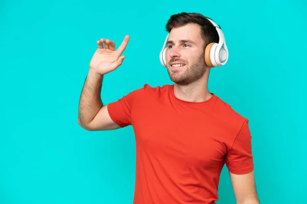 Jonge Blanke Man Geïsoleerd Blauwe Achtergrond Luisteren Muziek Dansen — Stockfoto