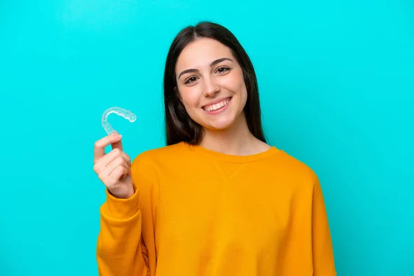 Young Caucasian Woman Holding Invisible Braces Isolated Blue Background Smiling — Zdjęcie stockowe