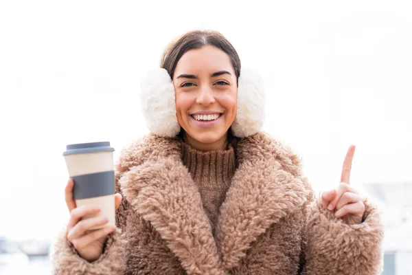年轻女人穿着冬衣 在户外拿着咖啡 提出了一个很好的主意 — 图库照片