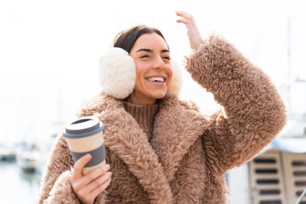 年轻女人穿着冬衣 在户外拿着咖啡 这让她意识到了什么 并打算解决这个问题 — 图库照片