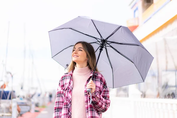年轻而漂亮的罗马尼亚女人举着雨伞 微笑着抬头看着外面 — 图库照片