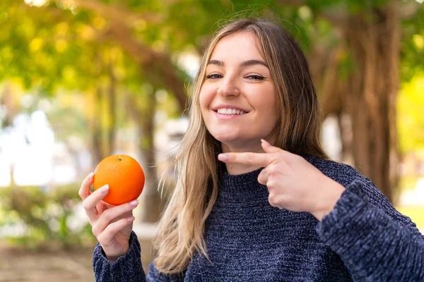 Jonge Mooie Roemeense Vrouw Houdt Een Sinaasappel Buitenlucht Wijzen — Stockfoto