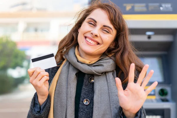 Mujer Morena Sosteniendo Una Tarjeta Crédito Aire Libre Saludando Con —  Fotos de Stock
