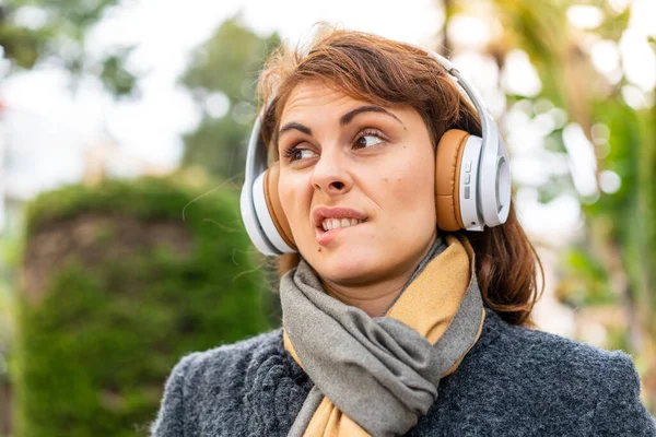 Μελαχρινή Γυναίκα Ακούγοντας Μουσική Ακουστικά Εξωτερικούς Χώρους Σύγχυση Έκφραση Προσώπου — Φωτογραφία Αρχείου