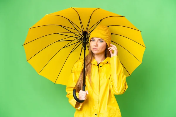 무지개 코트와 우산을 크로마의 배경에 의심을 — 스톡 사진