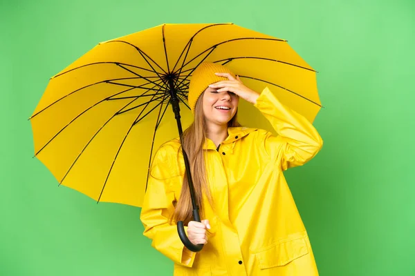 若いですブロンド女性とともにレインプルーフコートと傘上の隔離されたクロマキー背景笑顔多く — ストック写真