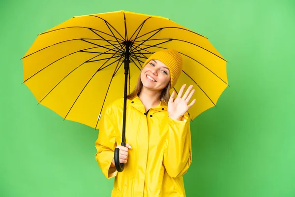 若いですブロンド女性とともにレインプルーフコートと傘上の隔離されたクロマキー背景Salatingとともに手で幸せな式 — ストック写真