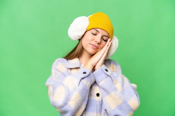 若いですブロンド女性身に着けています冬のマフ上の隔離されたクロマキー背景作ります睡眠ジェスチャーでDorable式 — ストック写真